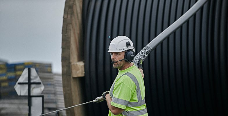 Cable worker pulling high voltage cable from a drum at onshore installation site in Trelleborg