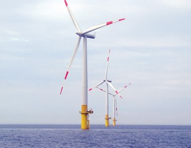 Three windmills at sea