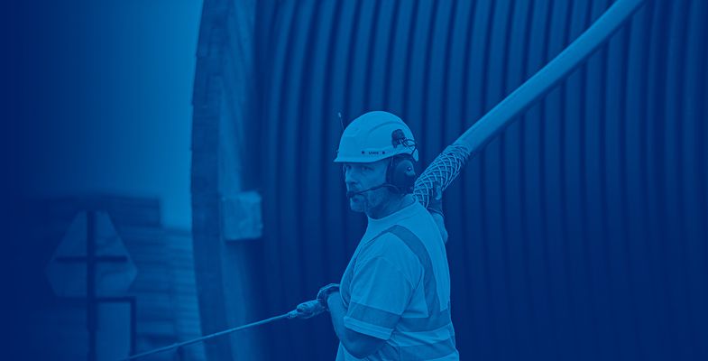Cable worker pulling high voltage cable from a drum at onshore installation site in Trelleborg