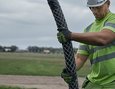 Cable worker pulling high voltage onshore cable from drum