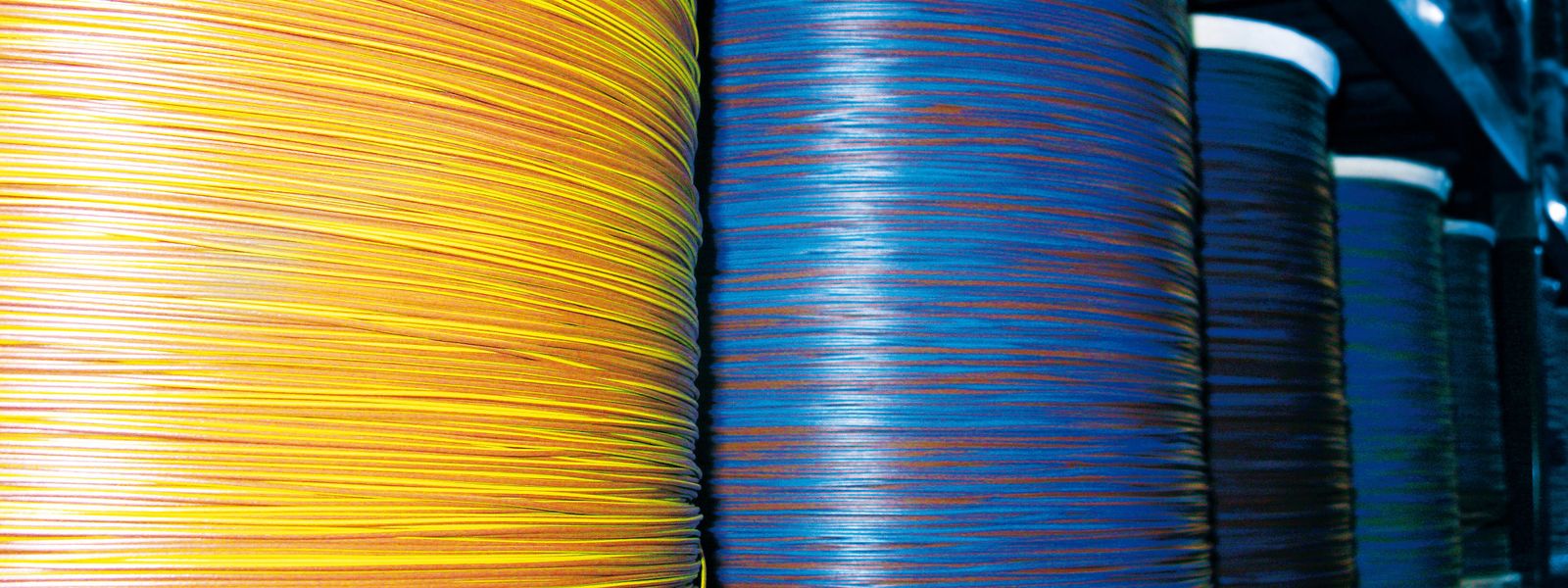 Blue and yellow automotive cables on large coils